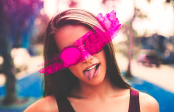 girl wearing rose colored glasses sticking out her tongue