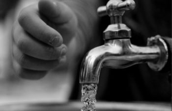 small hand reaching to turn off the water tap to save water