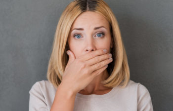 woman covering her mouth to hide discolored teeth