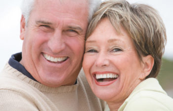 senior couple smiling and laughing because of their good oral health