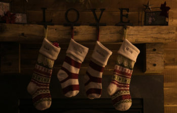 four Christmas stocking along the mantle held up with love holders