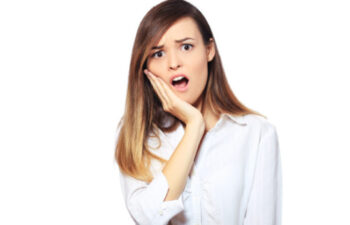 young woman holding her jaw in pain with a dental emergency