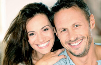 young couple smile showing off their cosmetic dentistry results