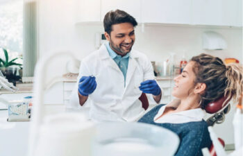 young woman gets a deep dental cleaning from the dentist